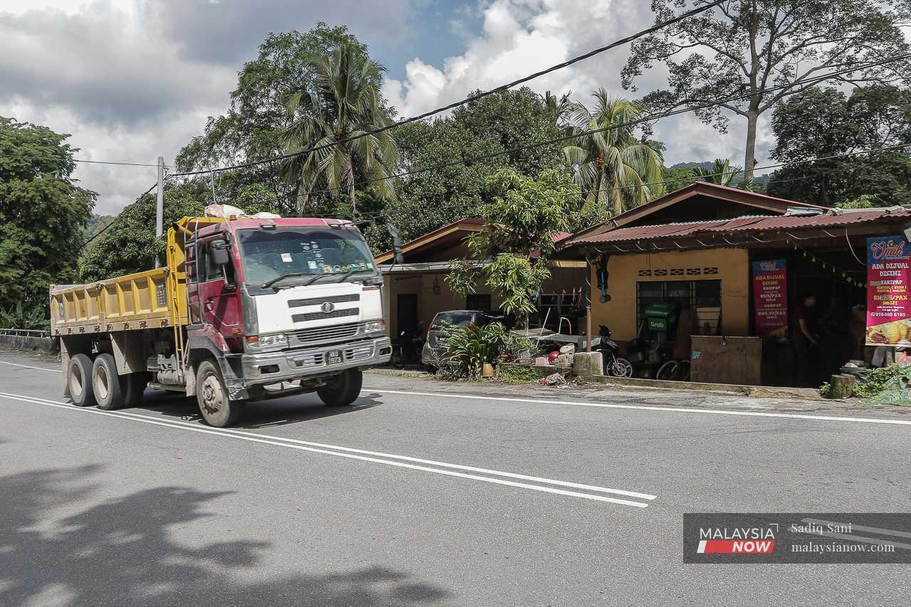A lorry involved in the project passes a row of houses by the side of Jalan Gombak. Residents say that such activities are causing cracks to appear in their walls. 