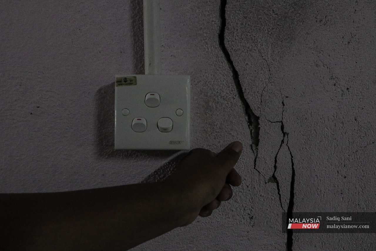 A villager shows one of the cracks in his wall. 