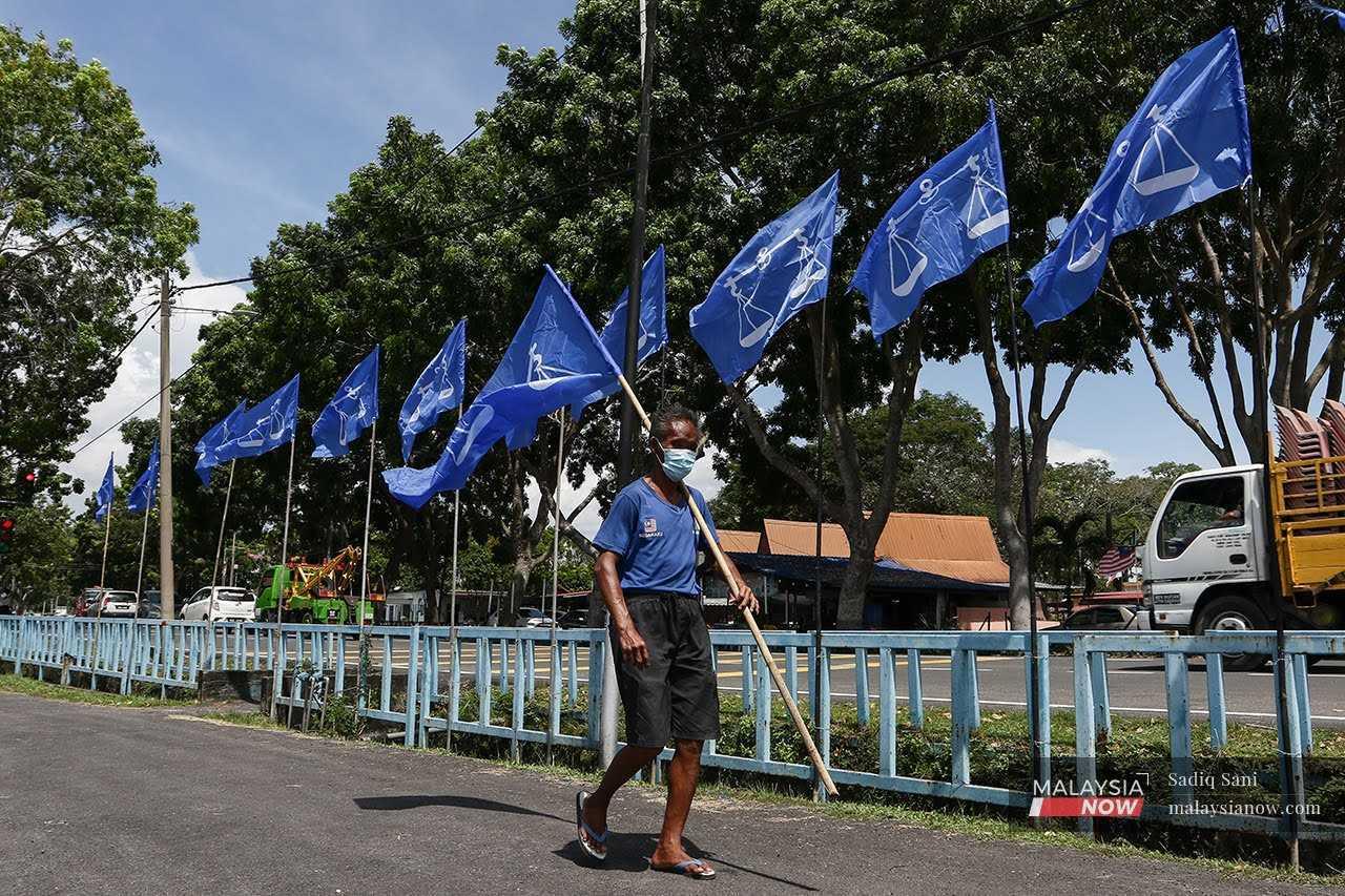 An election worker puts up Barisan Nasional flags in this 2021 file picture.