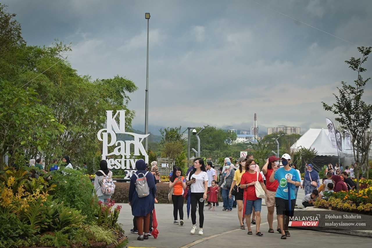 Pengunjung berjalan di sekitar Festival Taman KL, yang mempamerkan pelbagai spesies bunga dan tumbuhan, termasuk taman dalam balang yang dihasilkan Aziz.