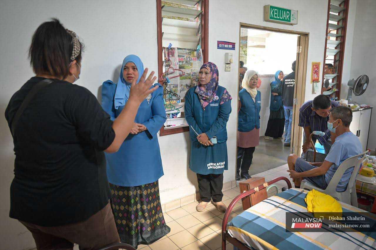 Perikatan Nasional candidate for Bukit Antarabangsa, Sasha Lyna Abdul Latif, visits the Ampang Welfare Committee and is briefed by its secretary, Alice Chia.