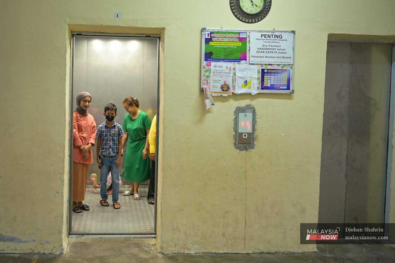 Penduduk memasuki lif di projek perumahan kos rendah di ibu kota Kuala Lumpur.