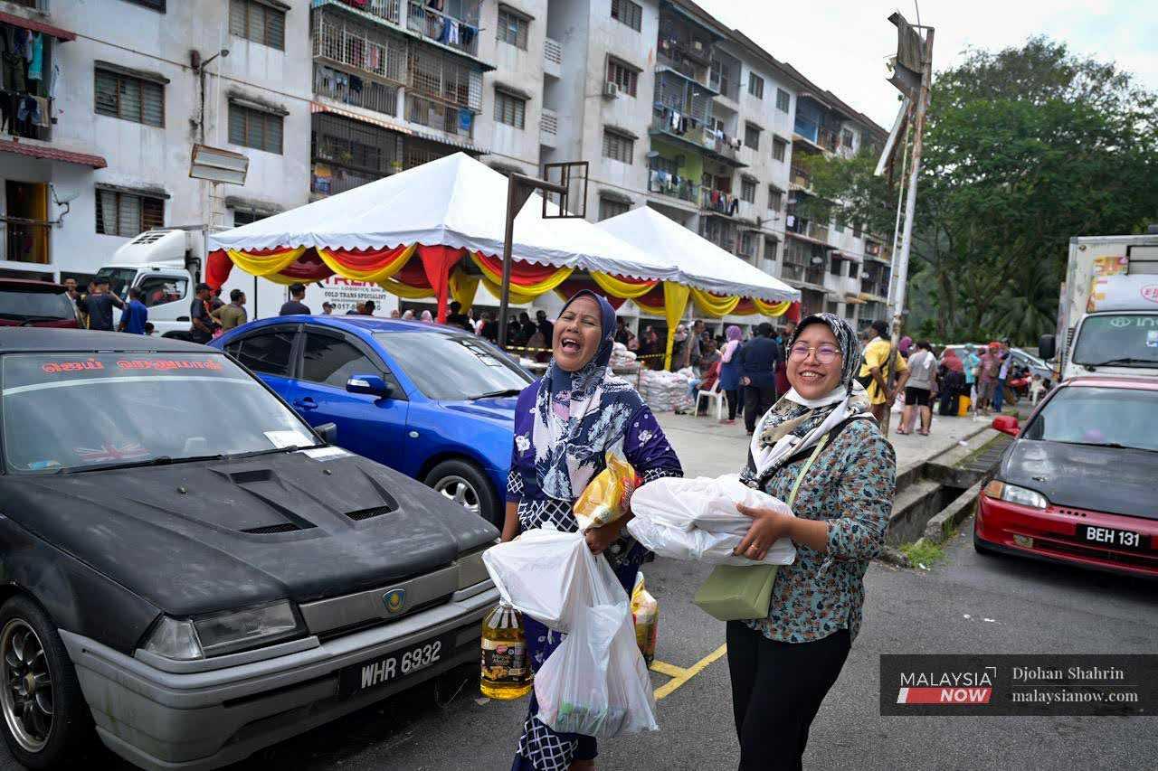 Two residents smile after buying basic necessities such as cooking oil, rice, and eggs.