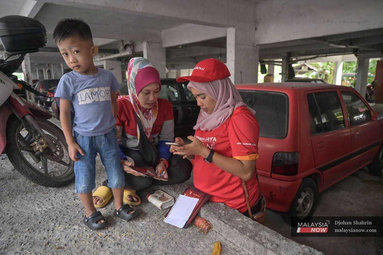 A Pakatan Harapan volunteer reads out several questions from the survey form and records them on an online Google platform.