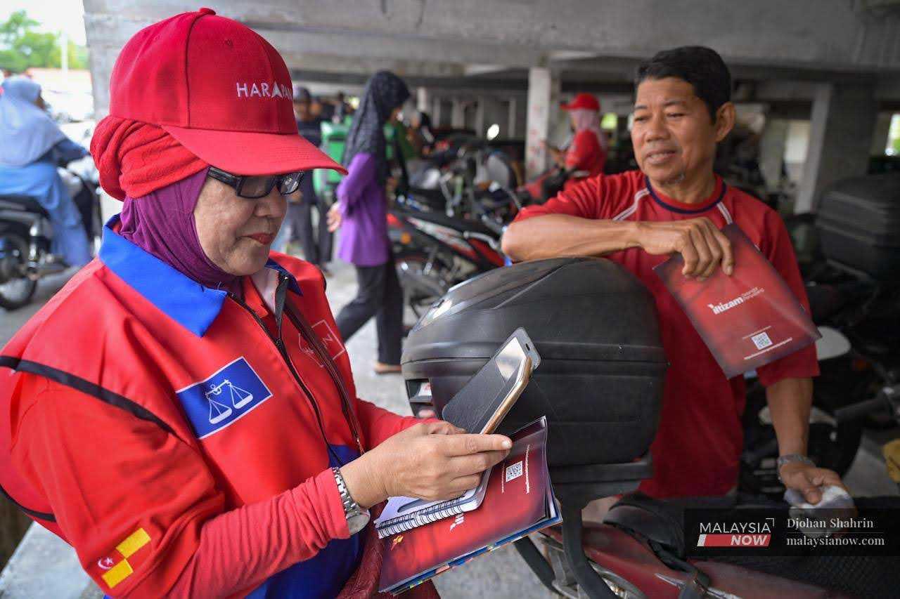 Machinery bearing the logos of Pakatan Harapan and Barisan Nasional conducts a satisfaction survey to gauge the performance of the state government under Pakatan Harapan's administration.