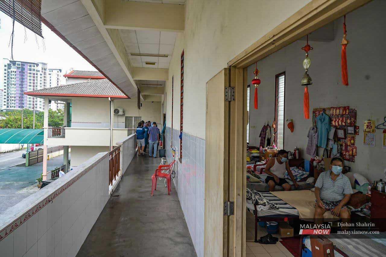 Elsewhere, elderly Chinese residents of Kampung Baru in Ampang go about their lives at the Ampang Welfare Committee. Some residents are resting on their beds.