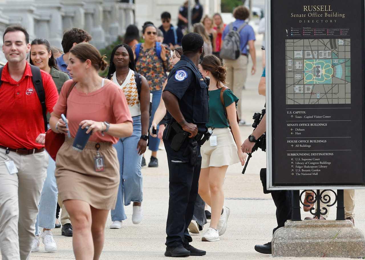 US Senate staff members evacuate under police supervision after an unconfirmed report of an active shooter spurred a lockdown in office buildings on Capitol Hill in Washington, Aug 2. Photo: Reuters