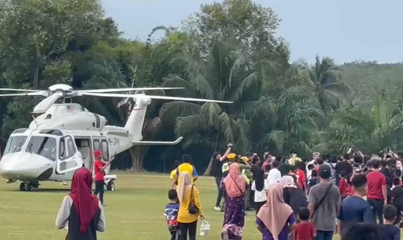 Penduduk kampung di Sik, Kedah, berpusu-pusu ke arah helikopter yang membawa Anwar Ibrahim yang mendarat berhampiran padang menjelang lawatan kempennya di kawasan itu pada 4 Ogos.