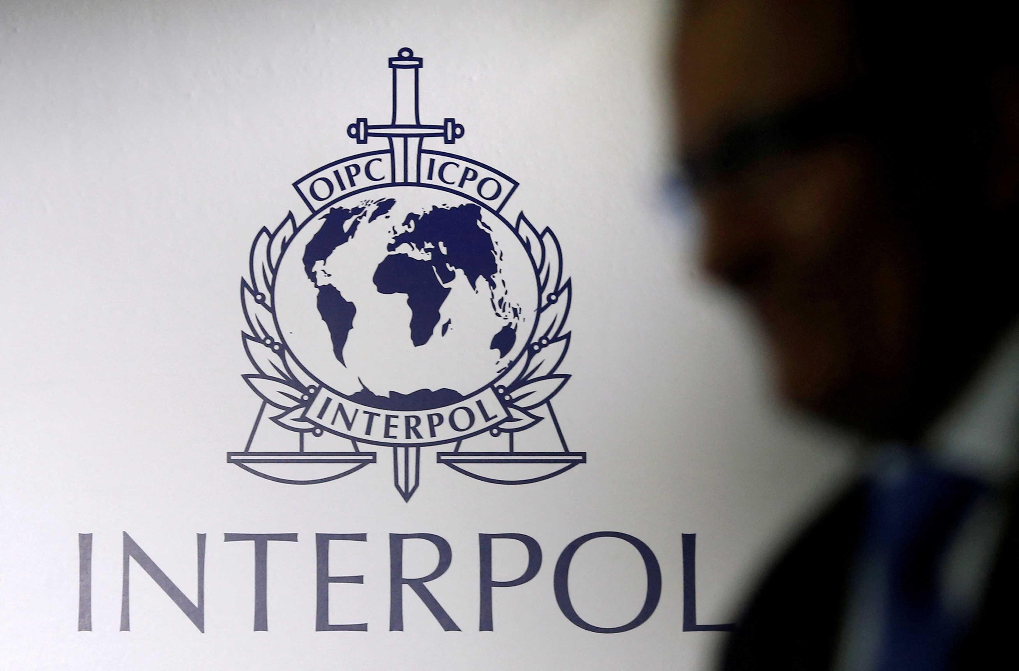 A man passes an Interpol logo during the handing over ceremony of the new premises for Interpol's Global Complex for Innovation, a research and development facility, in Singapore, Sept 30, 2014. Photo: Reuters