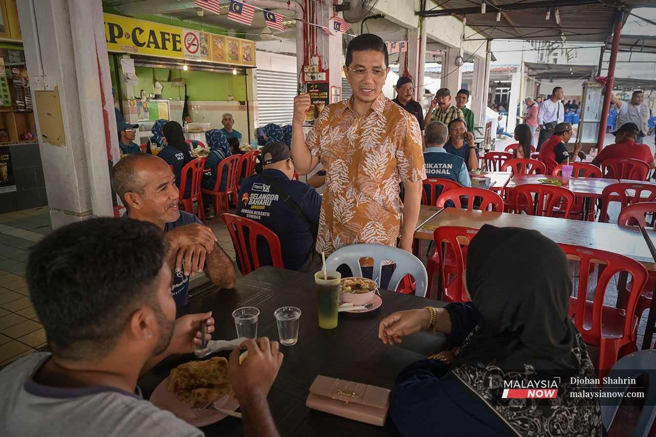 Azmin stops to speak to customers at an eatery as part of his campaign efforts. 