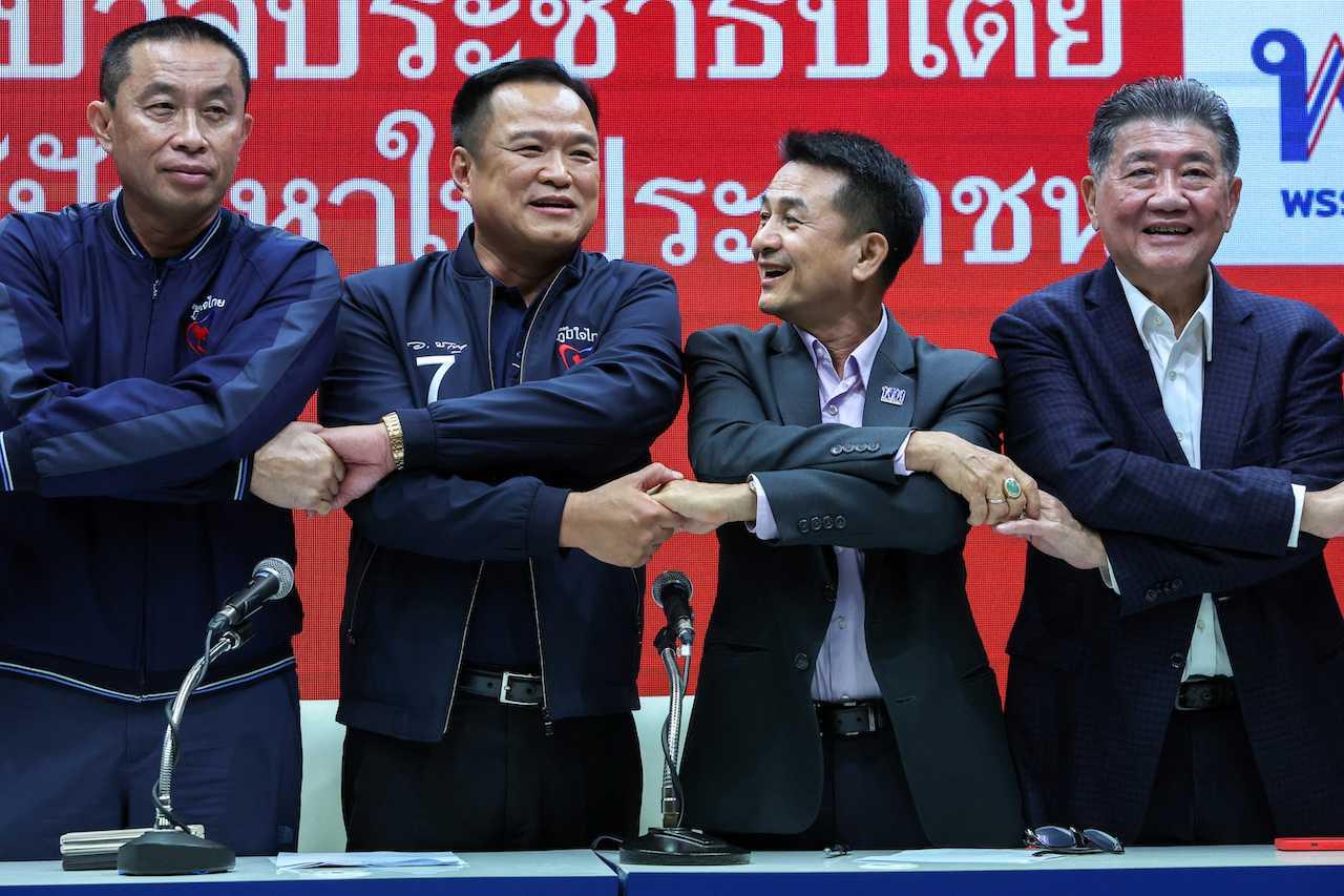 Pemimpin Parti Bhumjaithai Anutin Charnvirakul dan Pemimpin Parti Pheu Thai, Chonlanan Srikaew berjabat tangan selepas sidang media mengenai pembentukan pakatan antara Pheu Thai dan Bhumjaithai, di Bangkok, Thailand, 7 Ogos. Gambar: Reuters