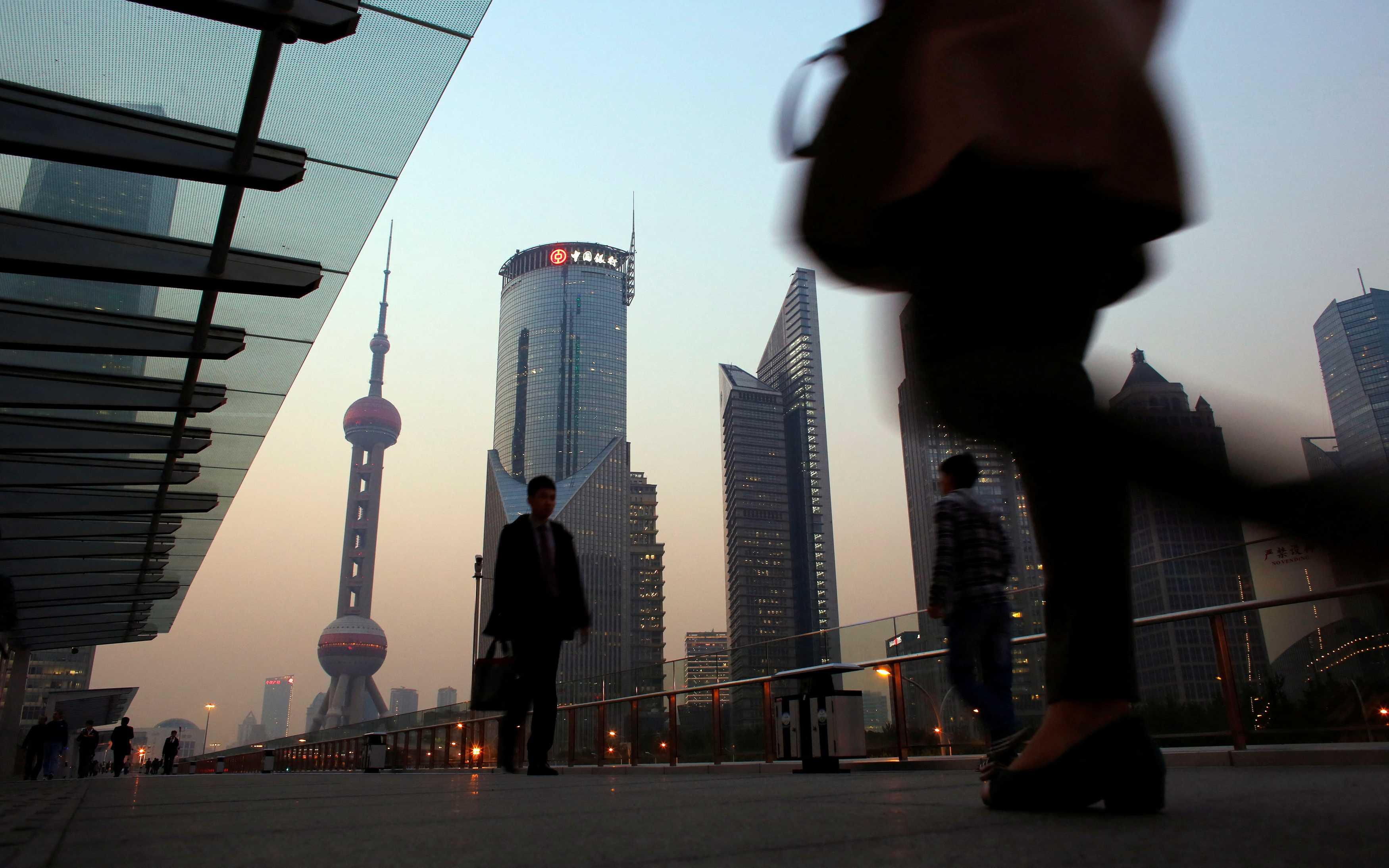 People walk along an elevated walkway at the Pudong financial district in Shanghai Nov 20, 2013. Photo: Reuters