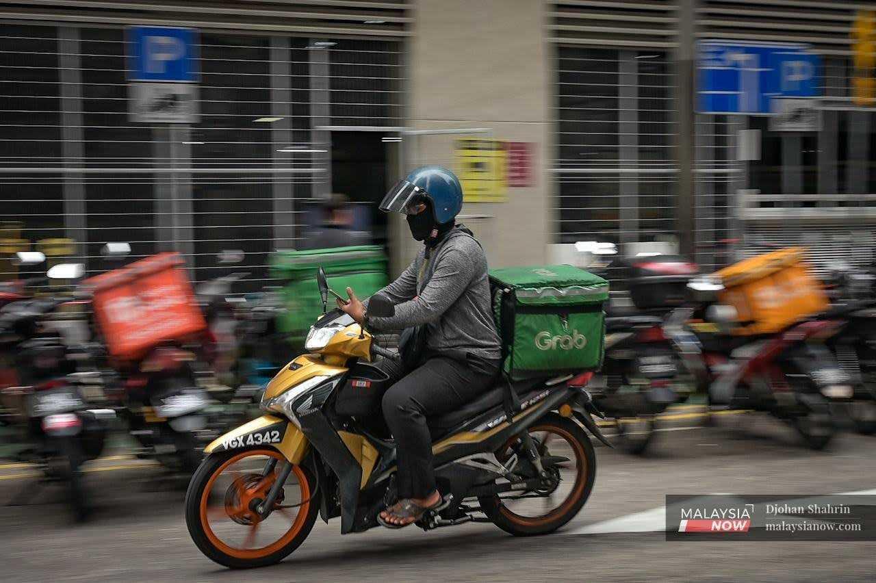 A food delivery rider checks an order in the Bukit Bintang district of Kuala Lumpur.