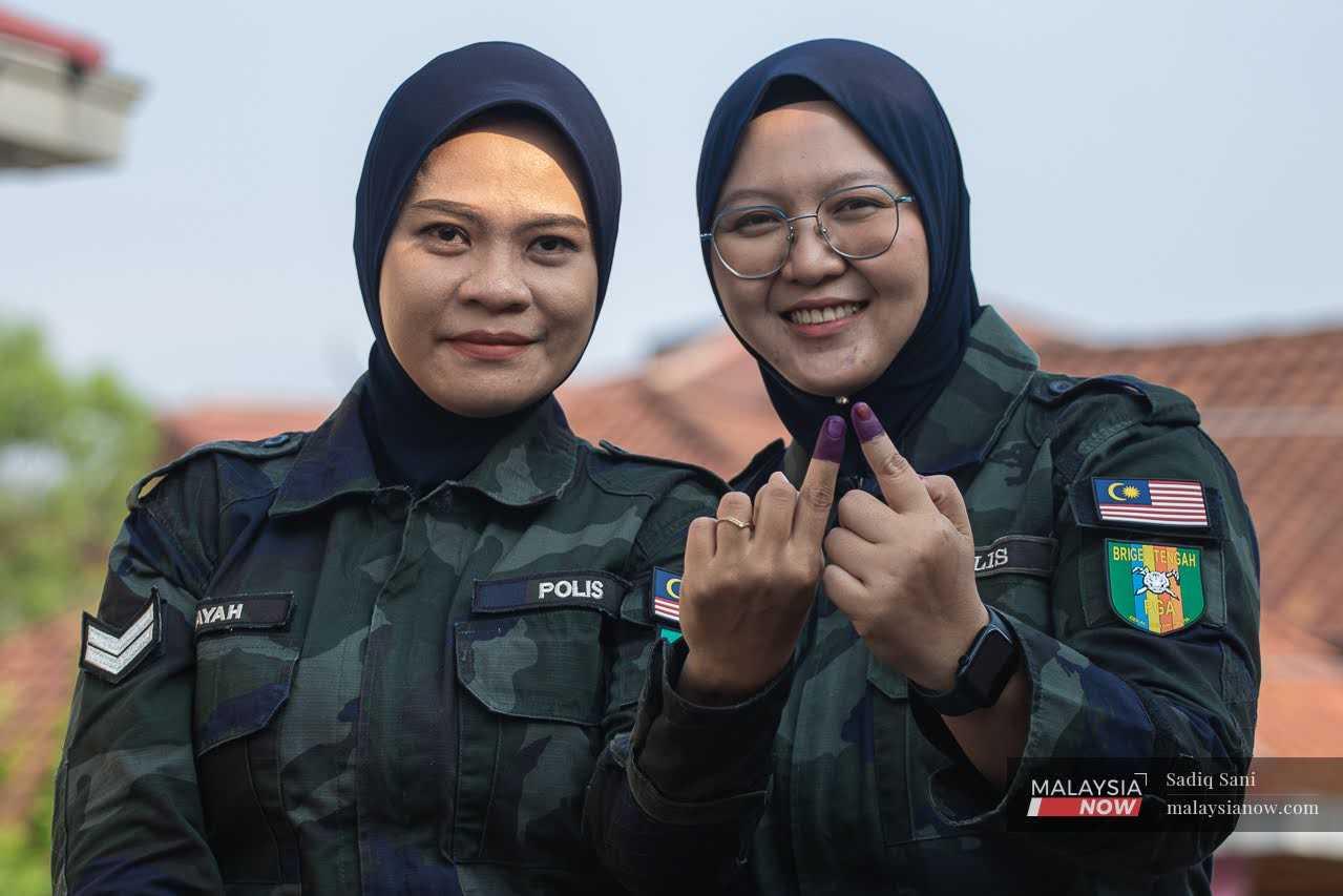 Anggota Pasukan Gerakan Am bergambar selepas selesai mengundi di Markas Briged Tengah Pasukan Gerakan Am di Cheras, 8 Ogos.
