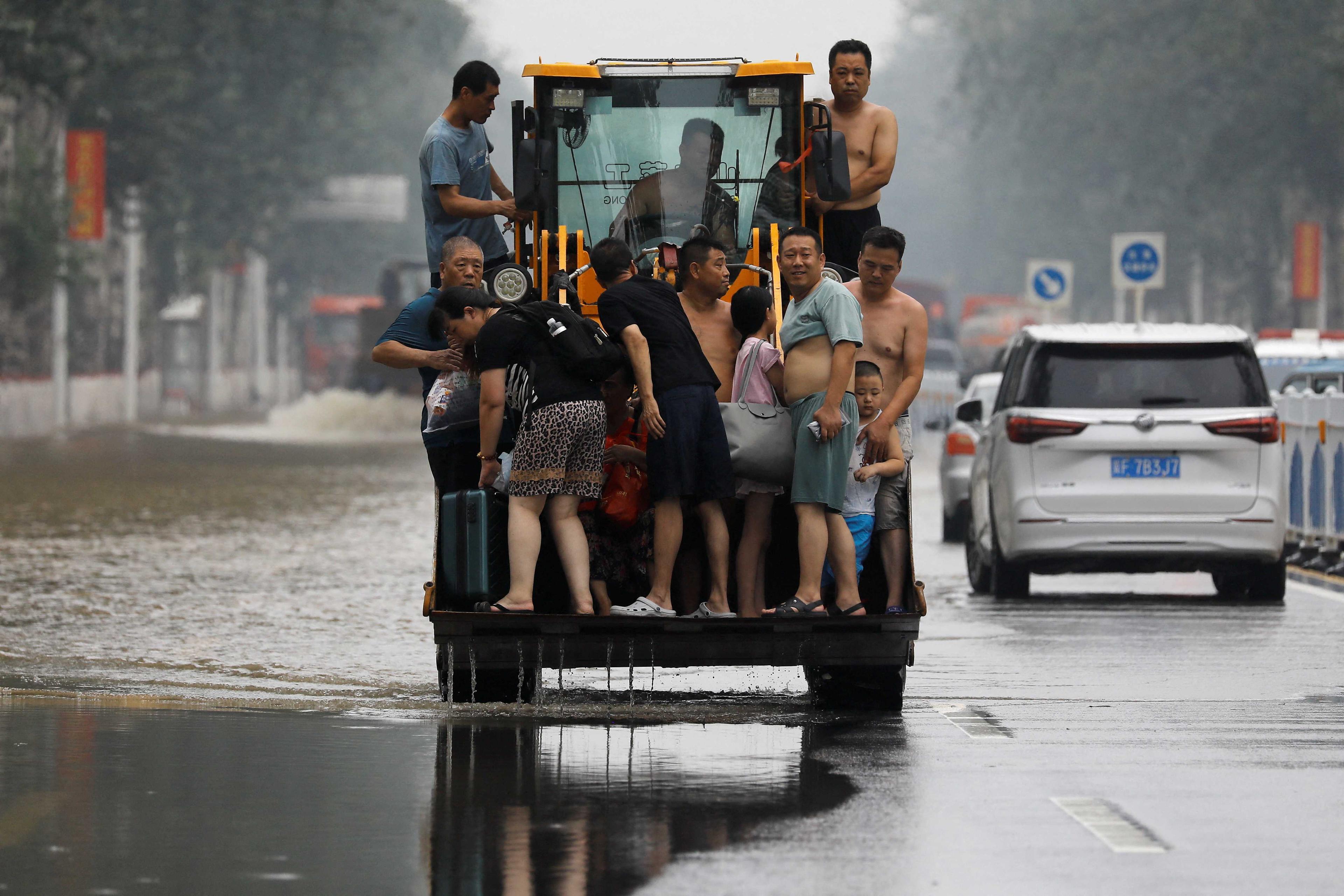 A man operates a front loader to evacuate people through a flooded road after the rains and floods brought by remnants of Typhoon Doksuri, in Zhuozhou, Hebei province, China Aug 3. Photo: Reuters