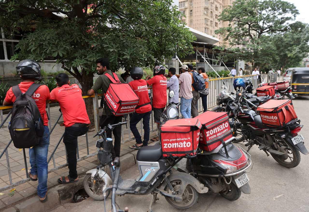 Gig workers wait in line to collect their delivery orders outside a mall in Mumbai, India, Aug 10. Photo: Reuters