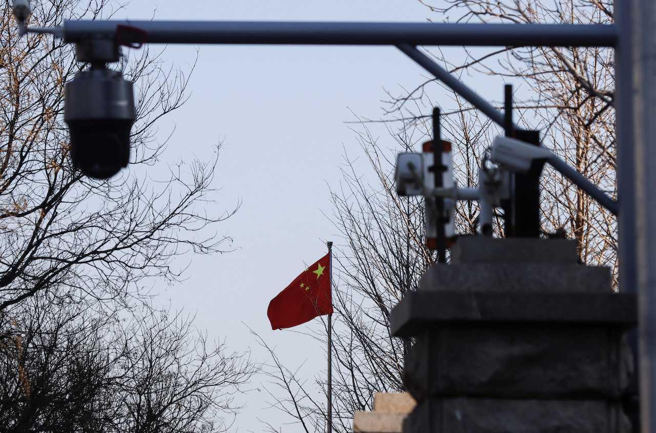 A Chinese flag is seen near surveillance cameras in Beijing, China, March 31. Photo: Reuters
