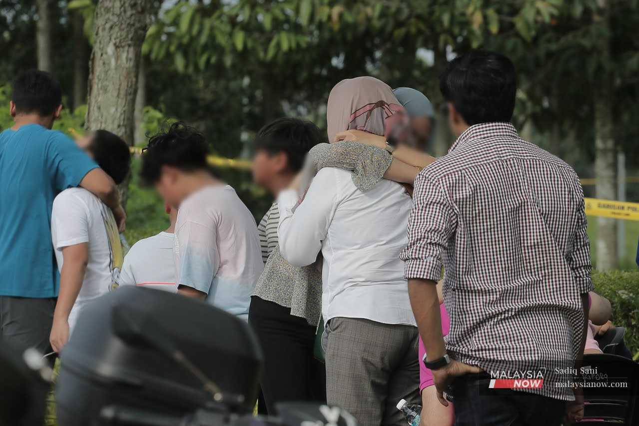 Relatives of the victims hug each other on the sidelines of the crash site.