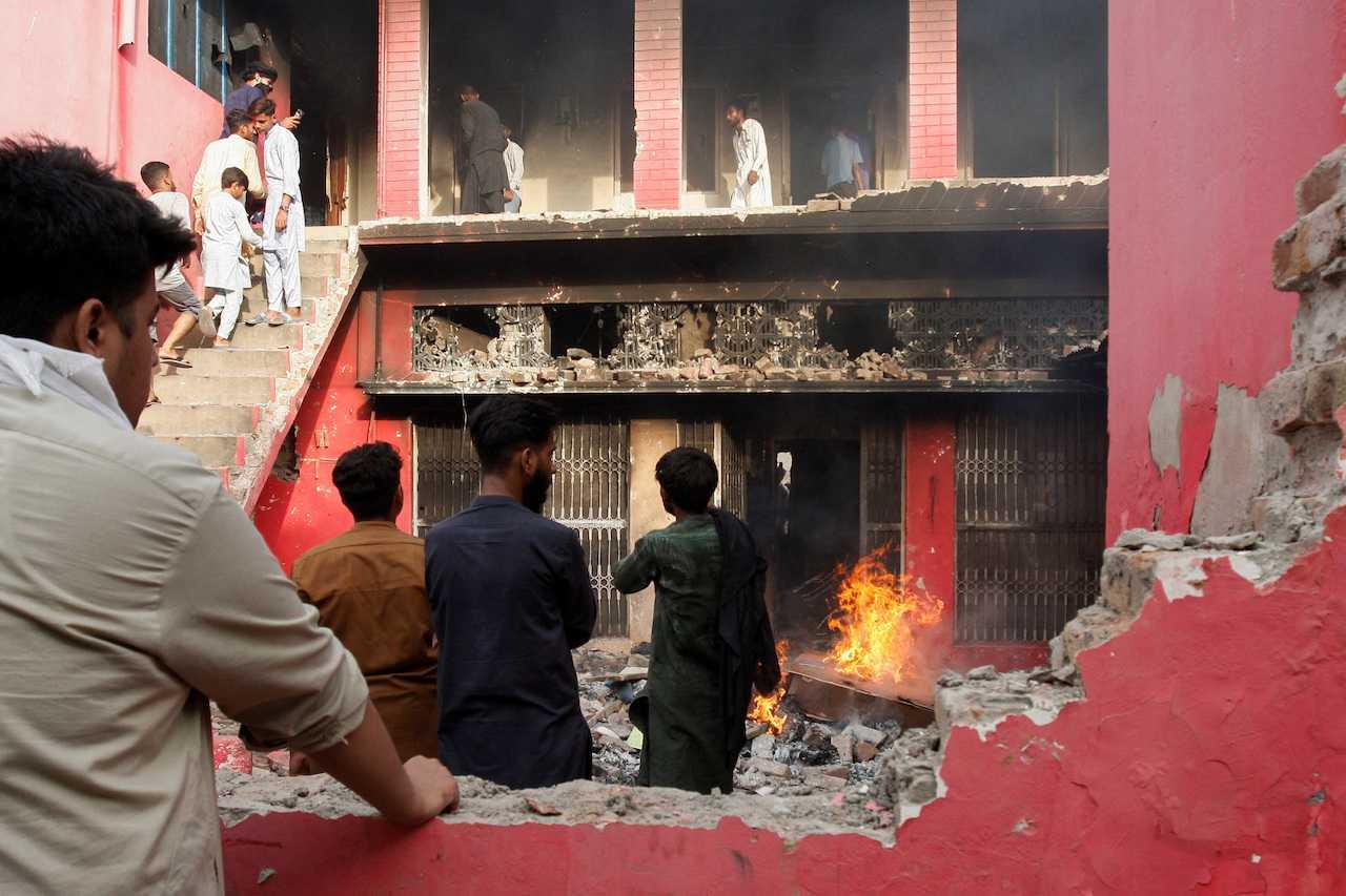 People gather at a church building vandalised by protesters in Jaranwala, Pakistan, Aug 16. Photo: Reuters