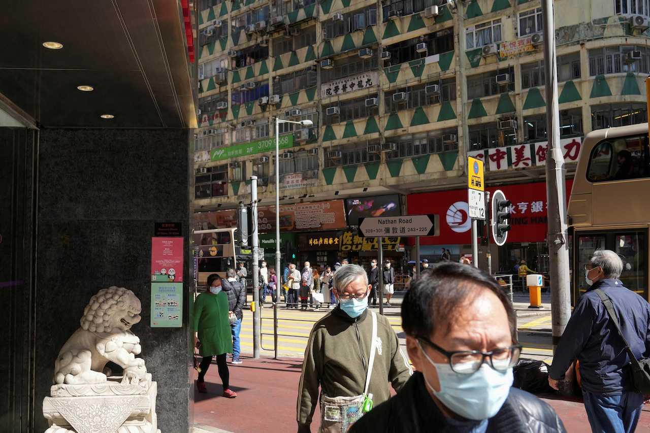 People wearing face masks to prevent the spread of Covid-19 walk on a street in Hong Kong, China, Dec 2, 2021. Photo: Reuters