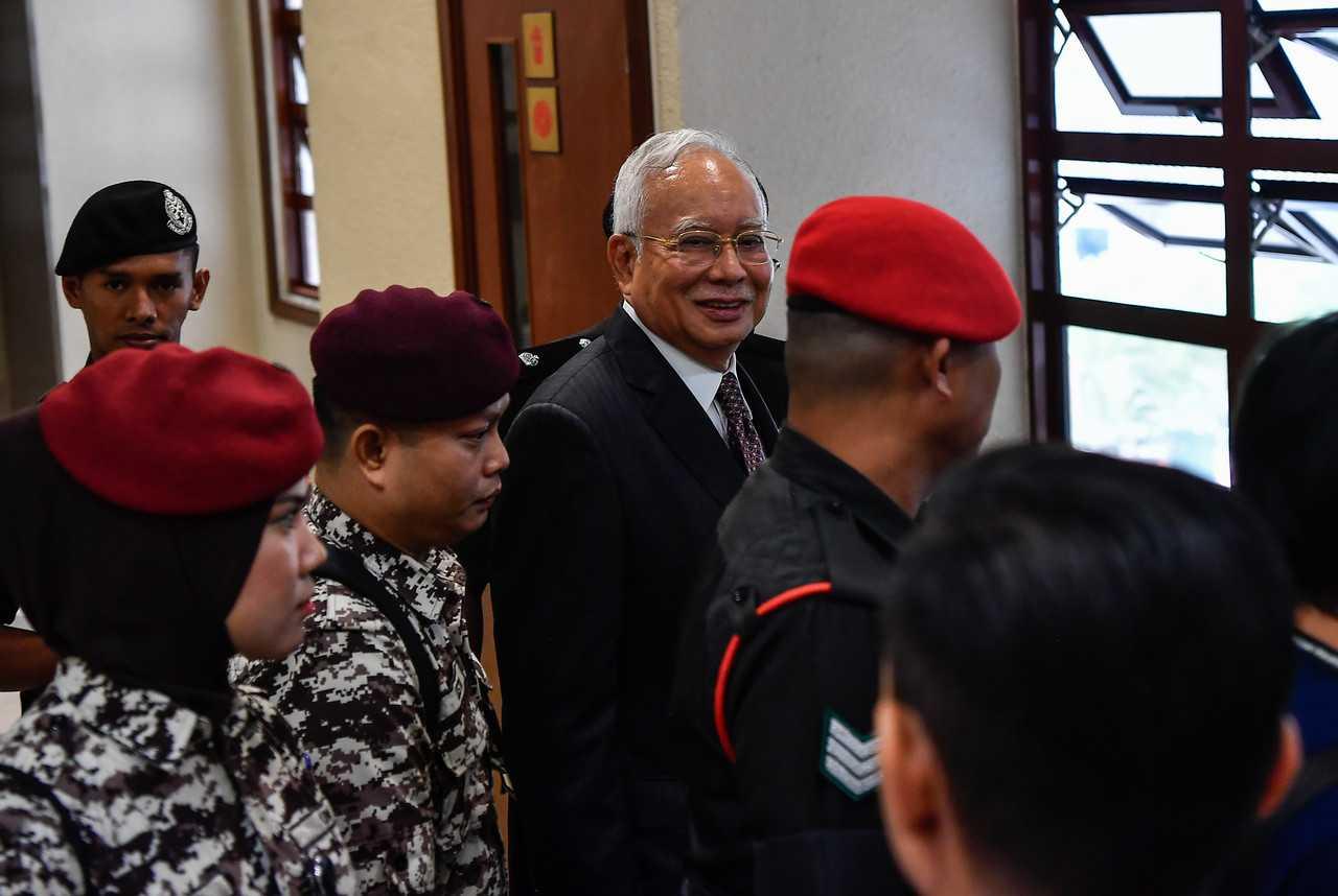 Former prime minister Najib Razak, escorted by security personnel at the Kuala Lumpur court complex today, Aug 18. Photo: Bernama