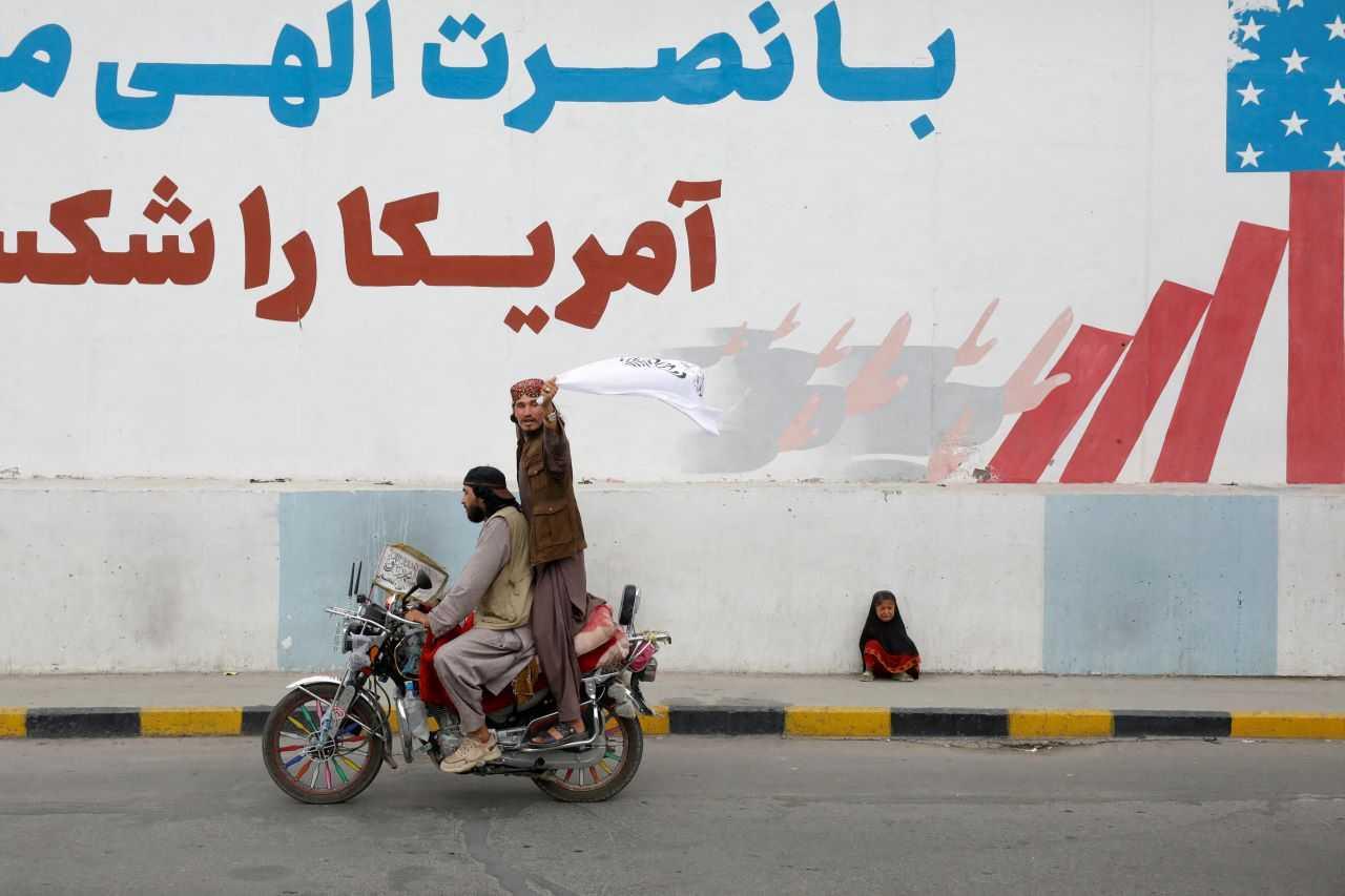 A Taliban supporter holds an Islamic Emirate of Afghanistan flag on the first anniversary of the fall of Kabul on a street in Kabul, Afghanistan, Aug 15, 2022. Photo: Reuters