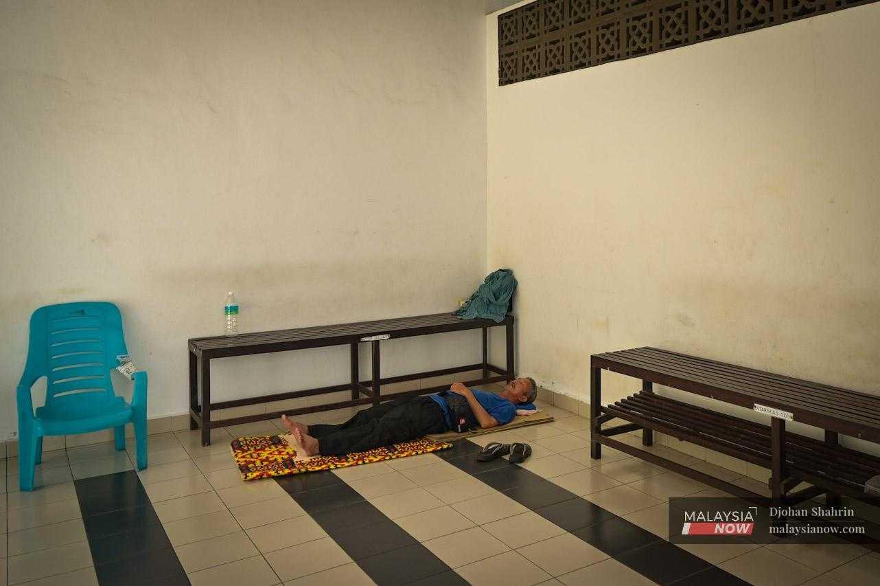In this space behind the restroom, Ah Kok finds temporary rest, uncertain of how long he could stay here. The highway management has advised him not to sleep in the area, but he can only appeal for their mercy, hoping to be given time until he manages to repair his car.