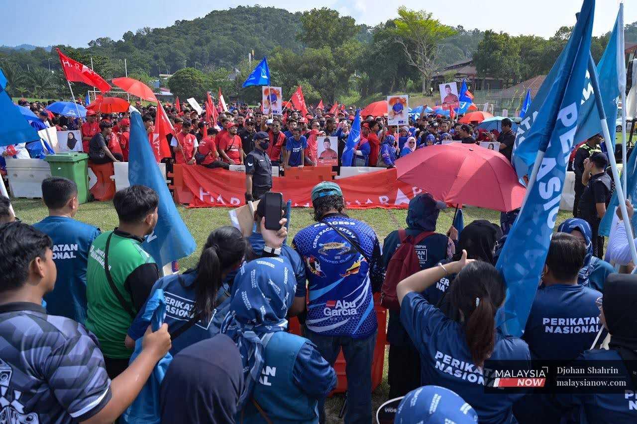 Supporters of Pakatan Harapan-Barisan Nasional and Perikatan Nasional face off outside a nomination centre in Selangor, on nomination day for the state election on July 29.