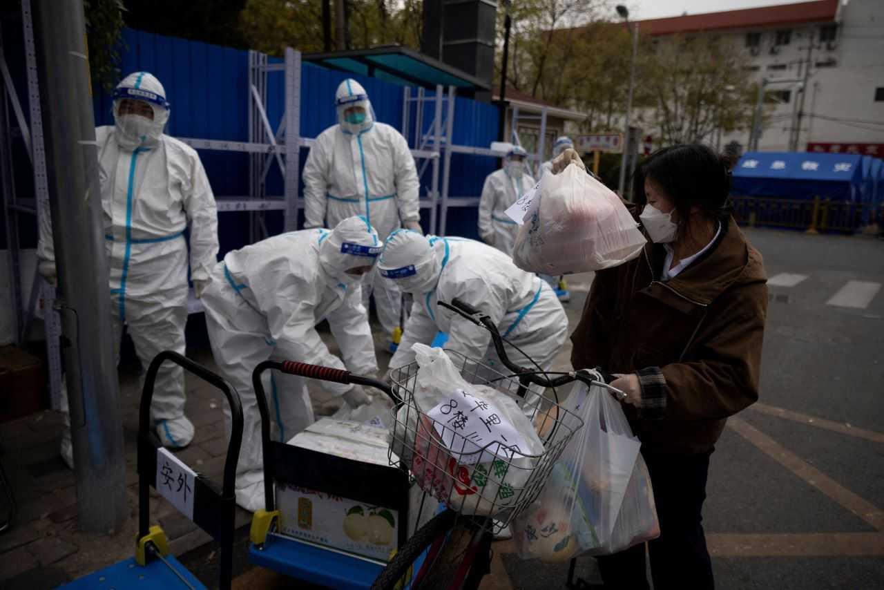 A woman delivers food to a residential compound that is under lockdown as outbreaks of Covid-19 continue in Beijing, China Nov 28, 2022. Photo: Reuters