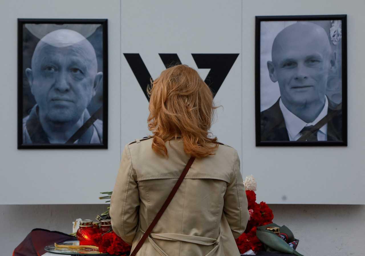 A woman stands in front of a makeshift memorial for Yevgeny Prigozhin, head of the Wagner mercenary group, and Dmitry Utkin, group commander, in Nizhny Novgorod, Russia, Aug 27. Photo: Reuters