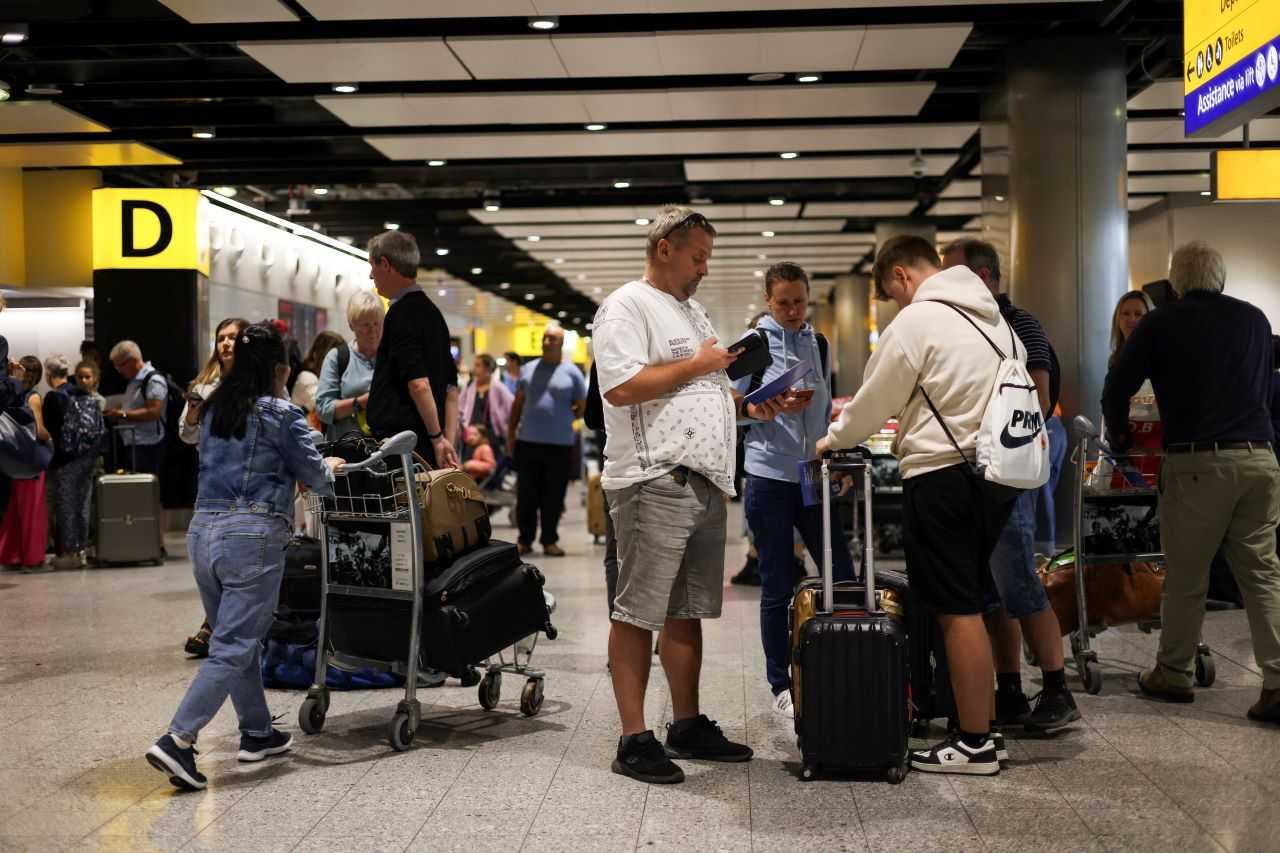 Travellers stand near the British Airways check-in area at Heathrow Terminal 3, as Britain's National Air Traffic Service (Nats) restricts UK air traffic due to a technical issue causing delays, in London, Britain, Aug 28. Photo: Reuters