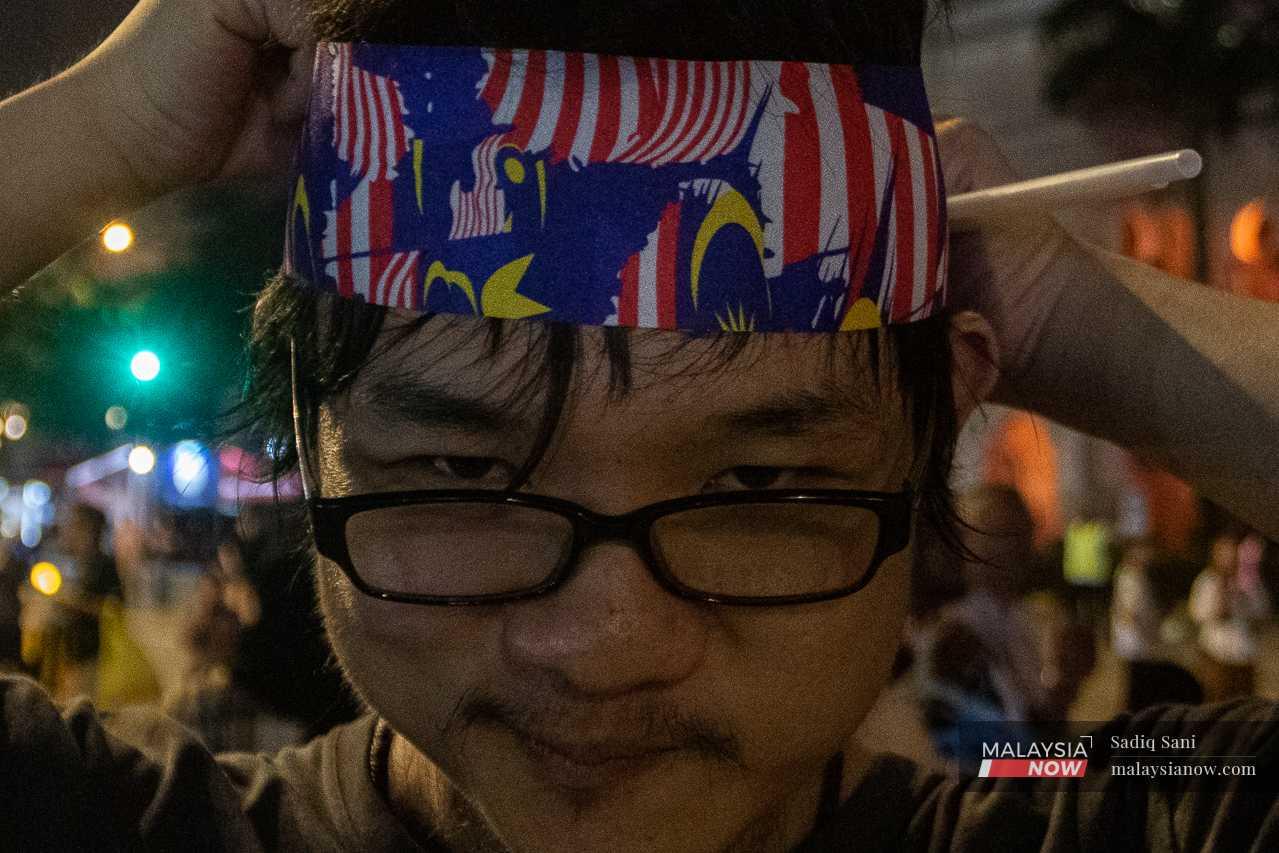 A man poses with a Jalur Gemilang headband at Dataran Merdeka in Kuala Lumpur. 
