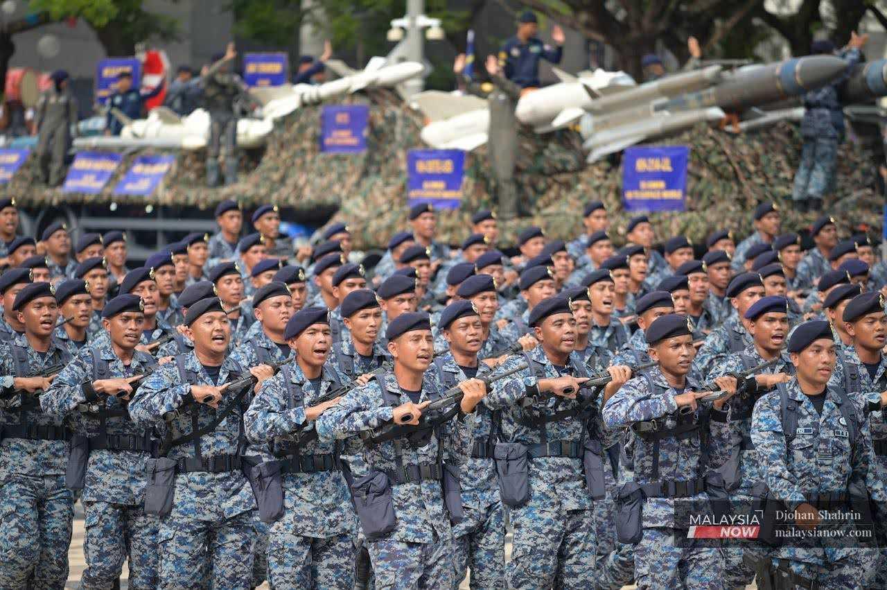 Members of the air force hold their weapons as they march. 