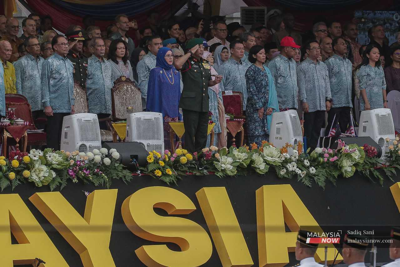 Yang di-Pertuan Agong Sultan Abdullah Sultan Ahmad Shah salutes during the parade, from his seat at the grandstand alongside Prime Minister Anwar Ibrahim and other government leaders. 