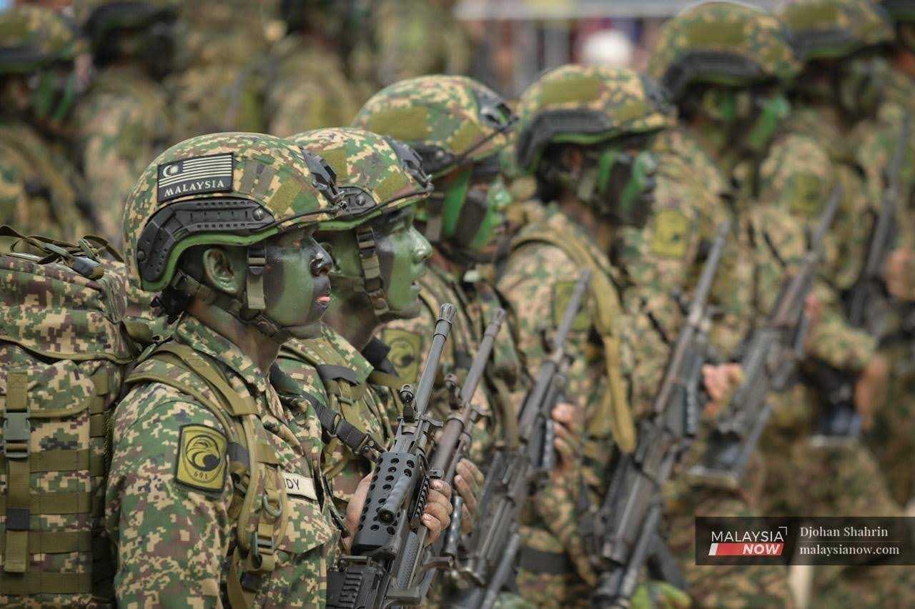 Army personnel in full camouflage participate in the parade.