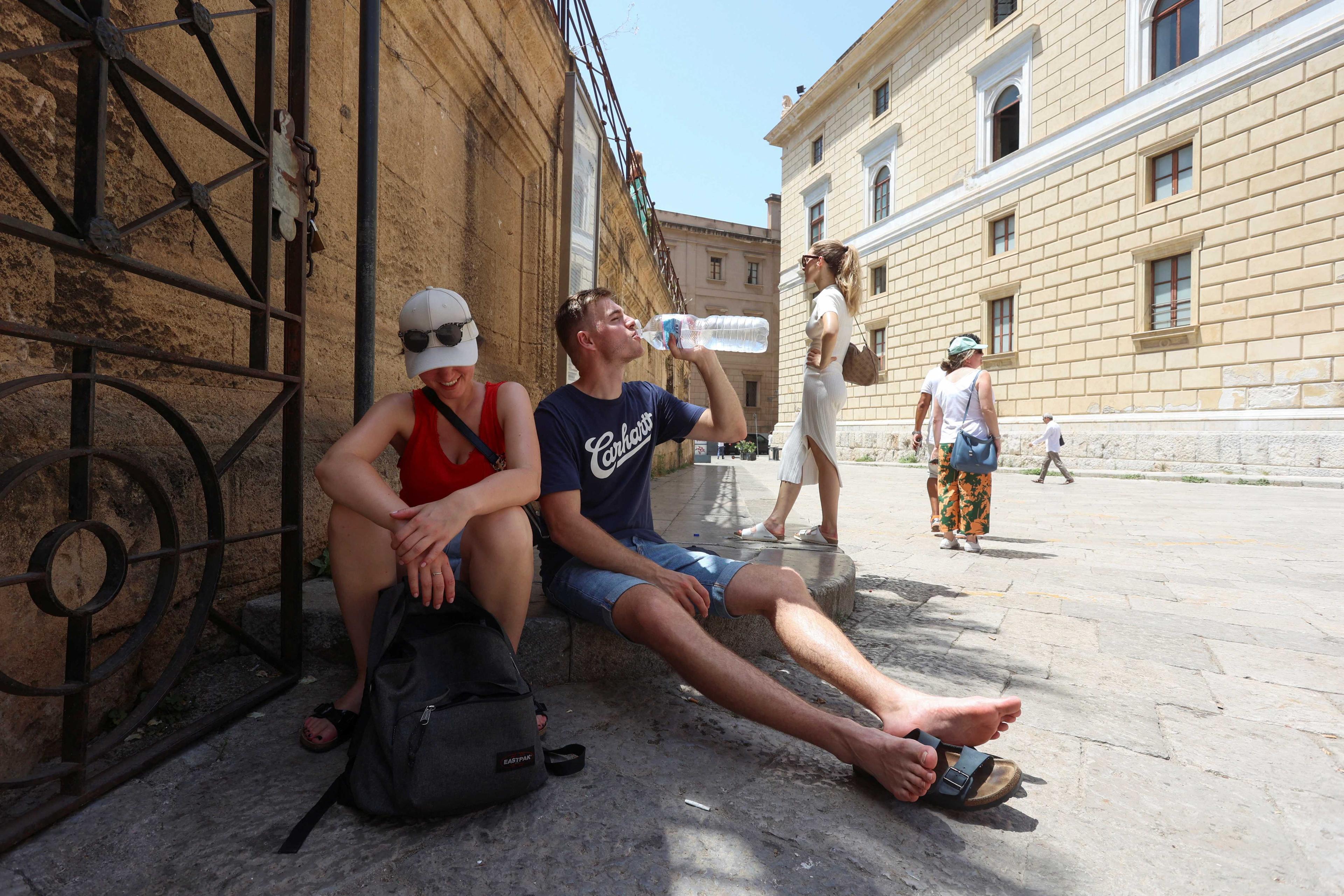 Pelancong duduk di tempat teduh untuk berlindung daripada pancaran matahari ketika gelombang panas melanda Palermo di Itali 19 Julai. Gambar: Reuters