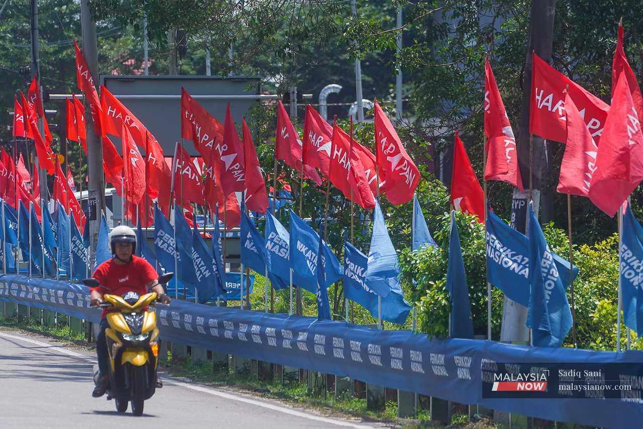 A motorcyclist passes a road decked out in Pakatan Harapan and Perikatan Nasional flags ahead of the by-election in Simpang Jeram, Johor, on Sept 9.