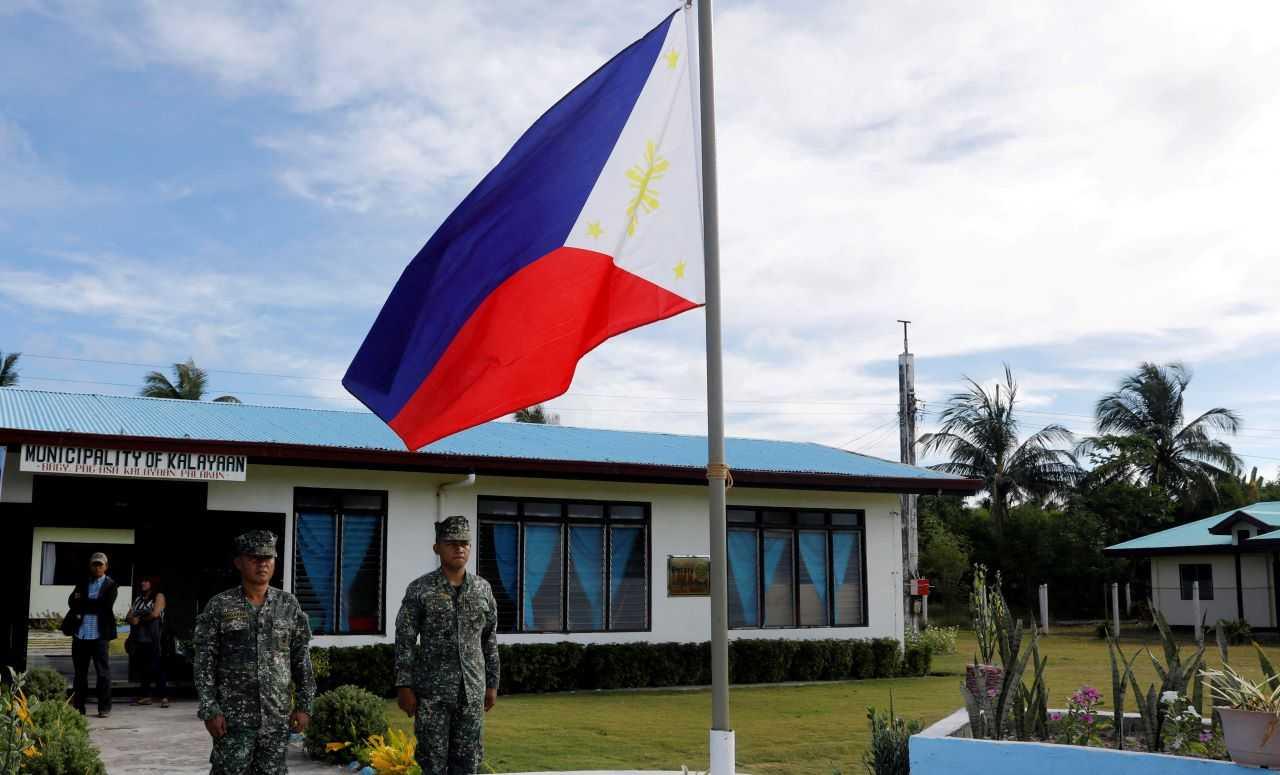 Filipino soldiers stand at attention near a Philippine flag at Thitu island in disputed South China Sea April 21, 2017. Photo: Reuters