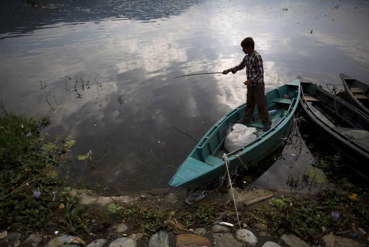 A boy tries to catch fish from the Phewa Lake in Pokhara, west of Nepal's capital Kathmandu June 29, 2015. Photo: Reuters