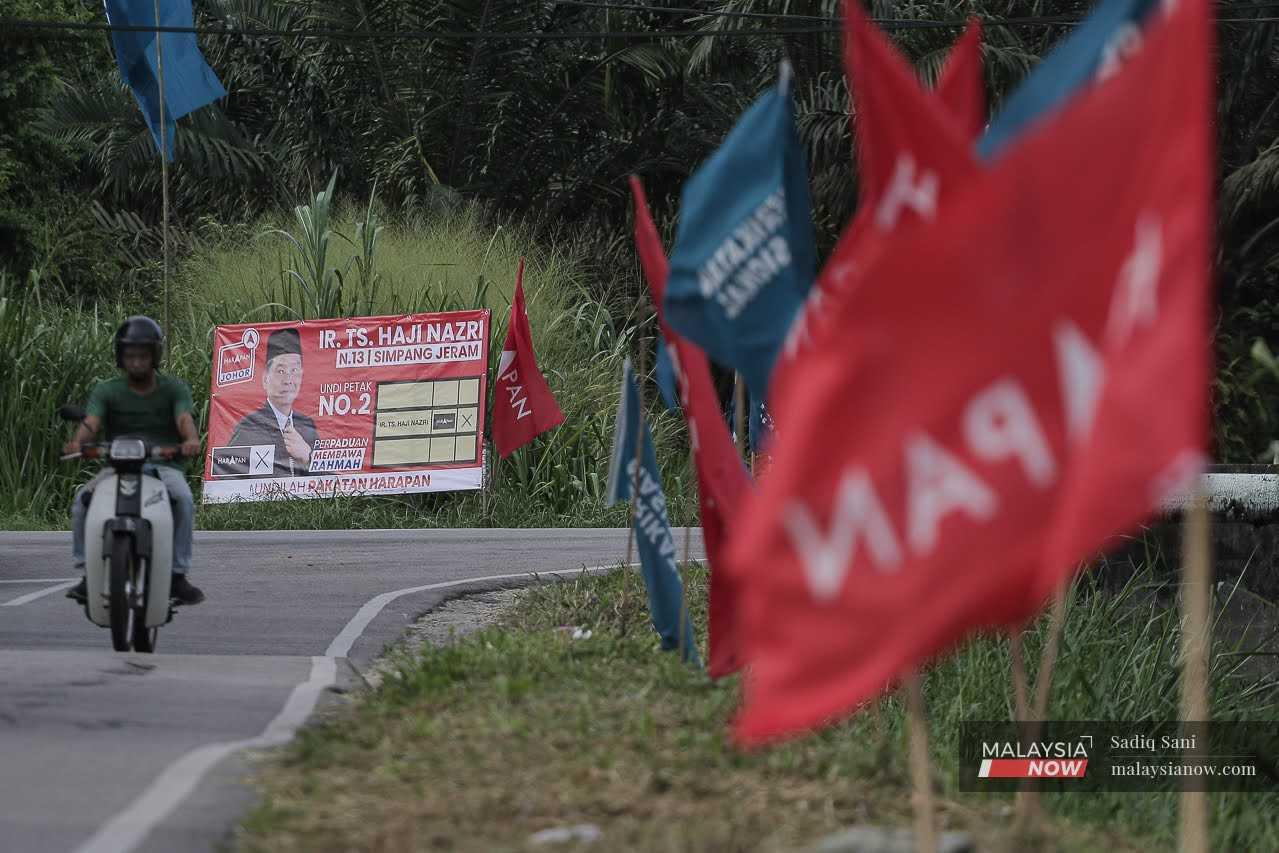 Sebuah poster memaparkan calon Pakatan Harapan Nazri Abdul Rahman di sebuah simpang di Kampung Bukit Batu menjelang PRK Simpang Jeram.