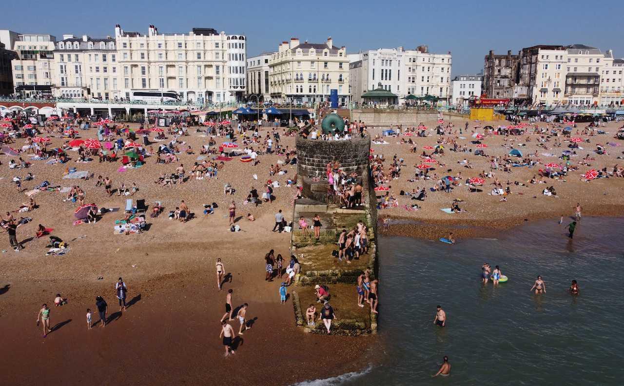 Beach-goers cool off in water to escape the heat in Brighton, Britain, Sept 9. Photo: Reuters