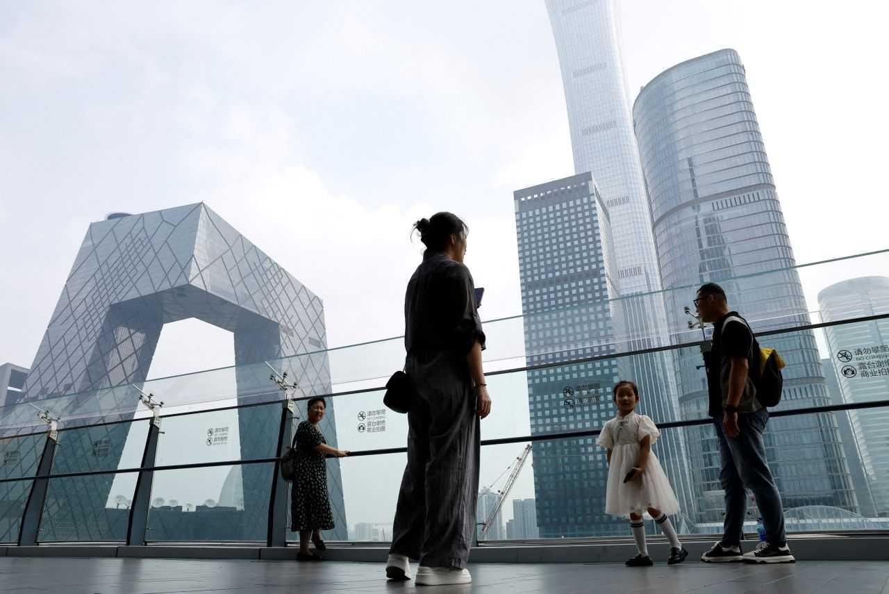 People stand at a shopping mall near the CCTV headquarters and China Zun skyscraper, in Beijing's central business district (CBD), China Sept 7. Photo: Reuters
