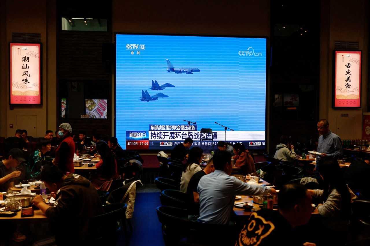Customers dine near a giant screen broadcasting news footage of aircraft of the Air Force under the Eastern Theatre Command of China's People's Liberation Army (PLA) taking part in a combat readiness patrol and 'Joint Sword' exercises around Taiwan, at a restaurant in Beijing, China April 10. Photo: Reuters