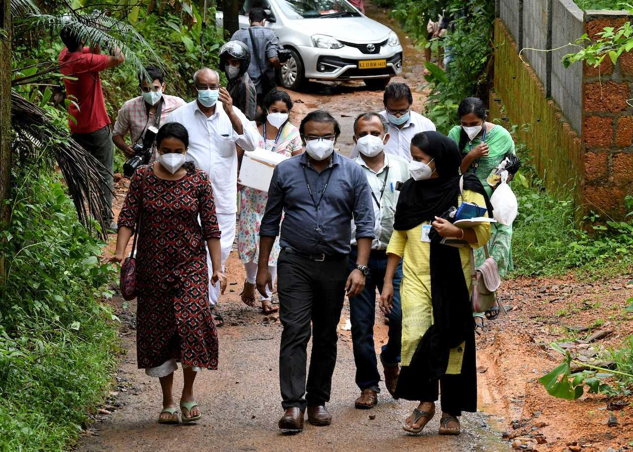 Members of a medical team carry areca nut and guava fruit samples to conduct tests for Nipah virus in Maruthonkara village in Kozhikode district, Kerala, India, Sept 13. Photo: Reuters