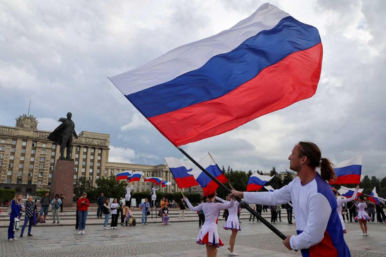 Participants wave Russian state flags during an event marking National Flag Day in Saint Petersburg, Russia, Aug 22. Photo: Reuters
