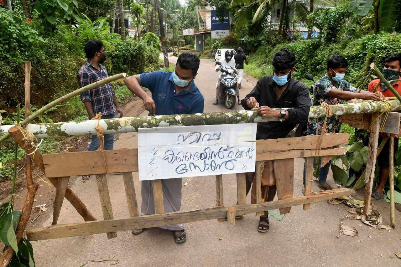 Residents fix a sign reading 'Nipah containment zone' on a barricade, put up to block a road after the authorities declared the area a containment zone, to prevent the spread of Nipah virus in Ayanchery village in Kozhikode district, Kerala, India, Sept 13. Photo: Reuters