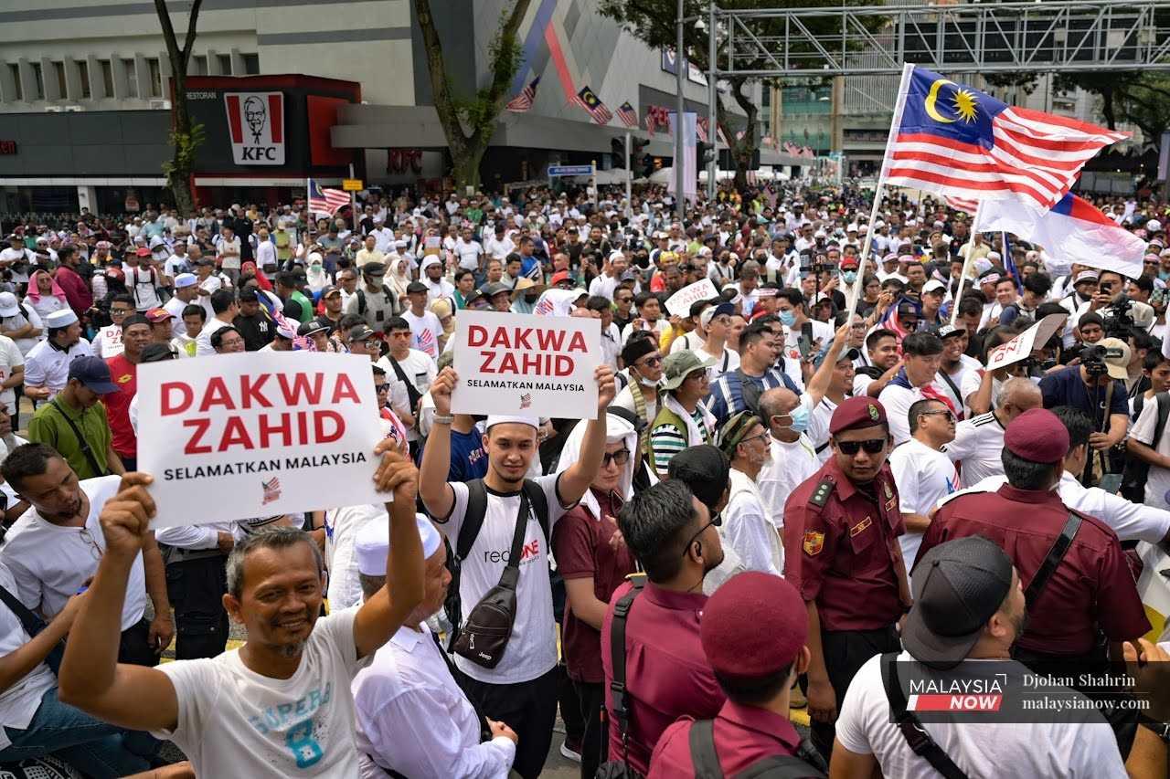 Demonstrators also hold up Malaysian flags as they make their way through the city in Jalan Tuanku Abdul Rahman. 