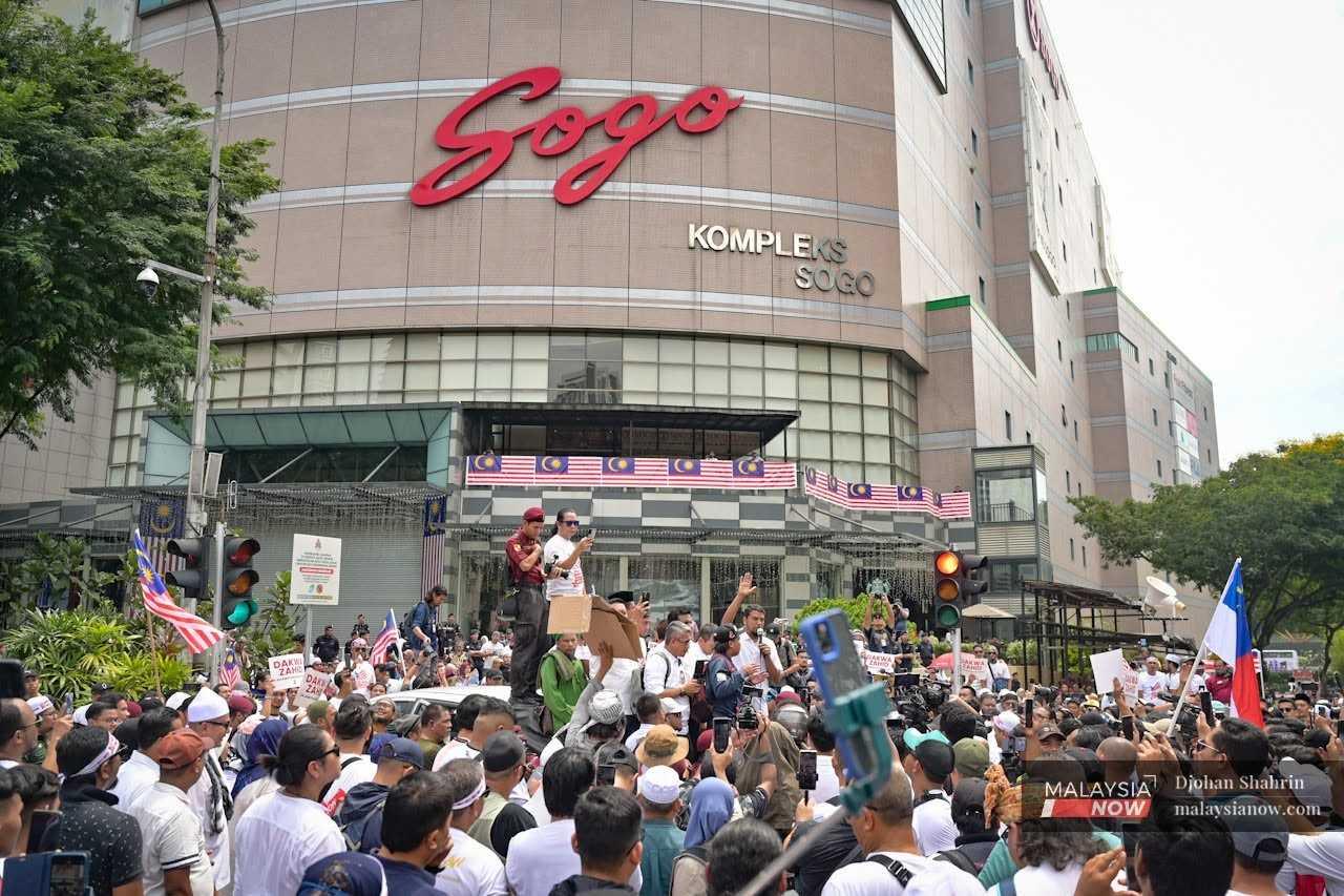 Orang ramai berkumpul di luar kompleks membeli-belah Sogo. 