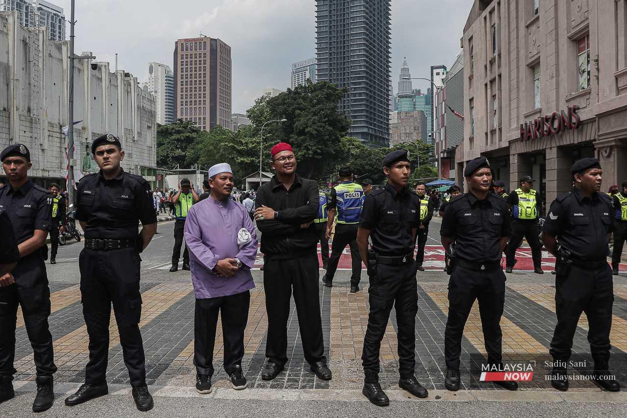 Police personnel stand by in Jalan Dang Wangi. 