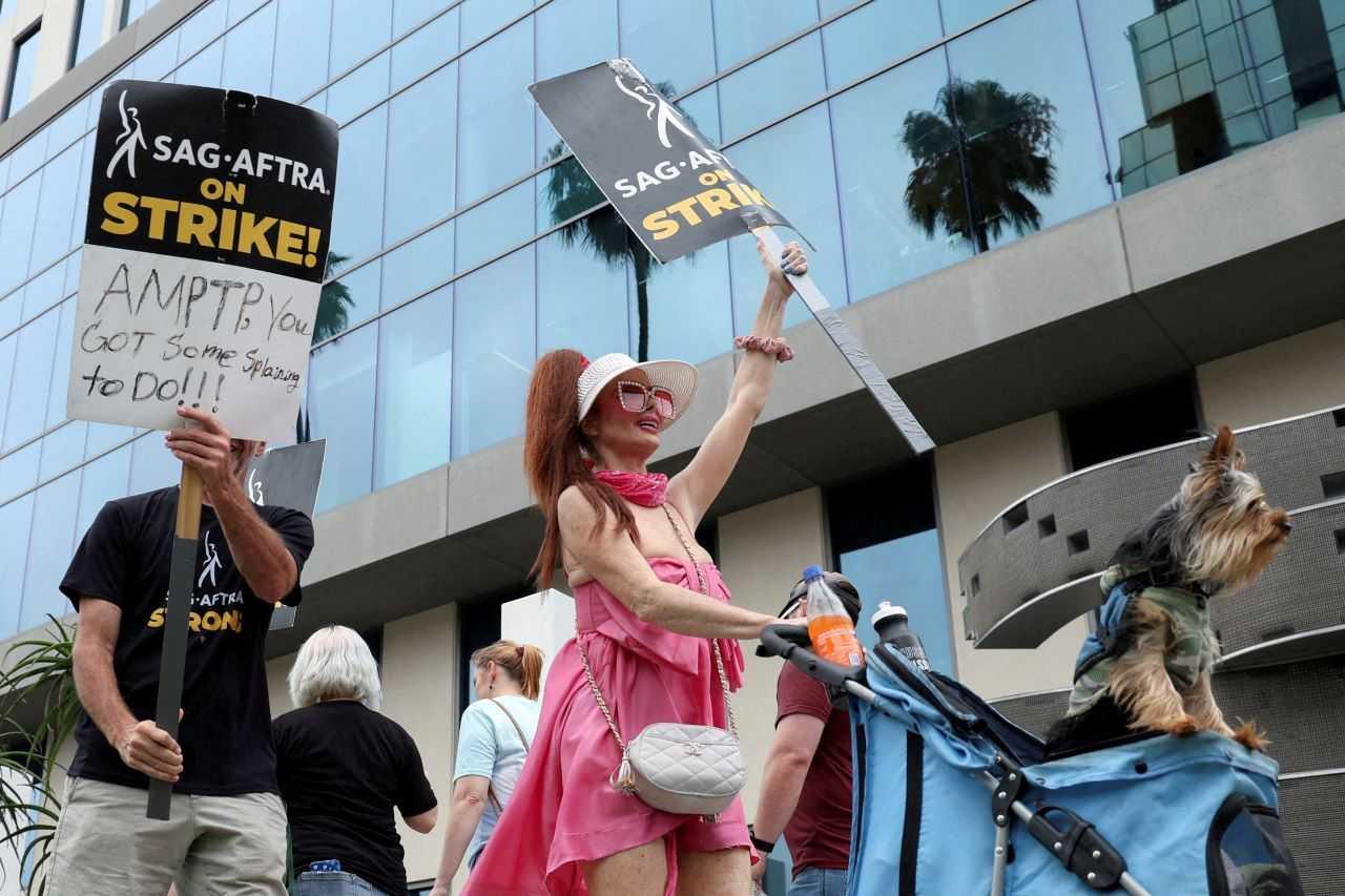 Phoebe Price holds a sign as SAG-AFTRA actors and Writers Guild of America (WGA) writers walk the picket line during their ongoing strike outside Sunset Bronson studios, near Netflix offices in Los Angeles, California, US, Aug 11. Photo: Reuters